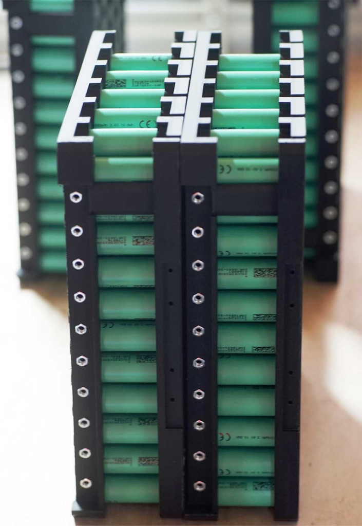 Mehrere gestapelte Lithium-Ionen-Rundzellen in schwarzen Halterahmen – Innenansicht eines Batteriemoduls