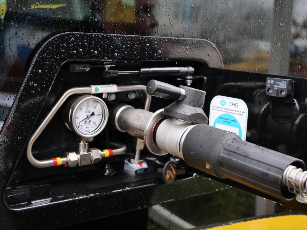 Nahaufnahme einer Wasserstoff-Zapfpistole mit Druckanzeige an einer Tankstelle für Wasserstoff-Omnibusse