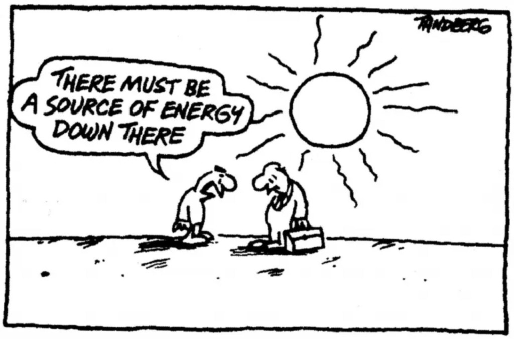 Cartoon von Tandberg: Zwei Männer mit gesenktem Blick suchen auf dem Boden nach einer Energiequelle, während im Hintergrund eine große, strahlende Sonne am Himmel steht. Sprechblase: 'There must be a source of energy down there' ('Da unten muss eine Energiequelle sein').