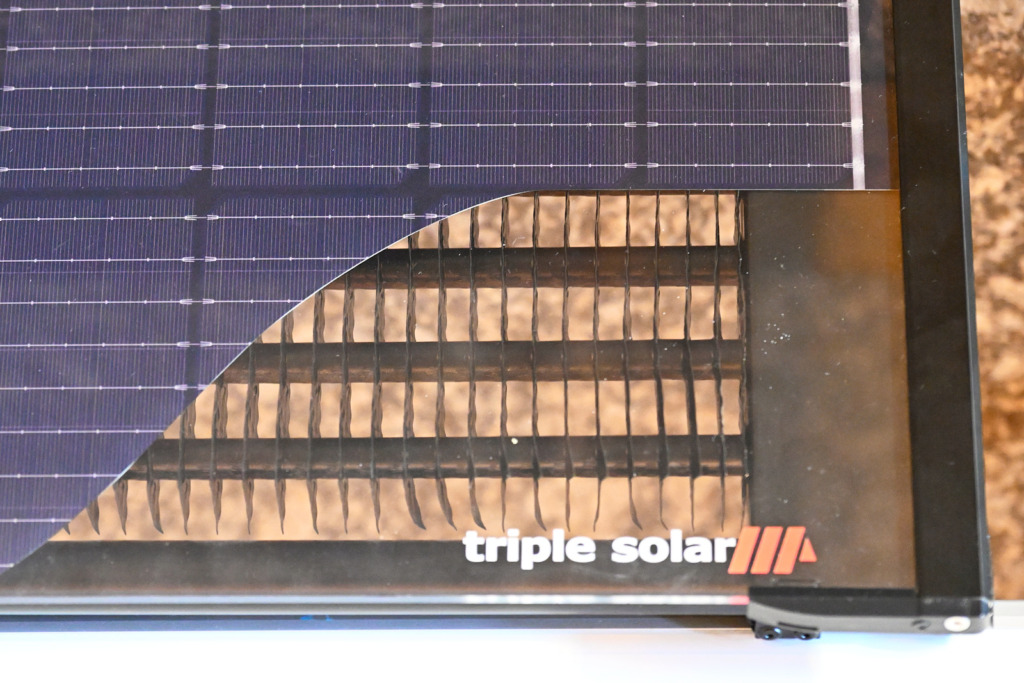 PV-T-Kollektor in Nahaufnahme: Ein Ausschnitt unter den Solarzellen zeigt den Wärmetauscher mit Lamellen auf der Rückseite.