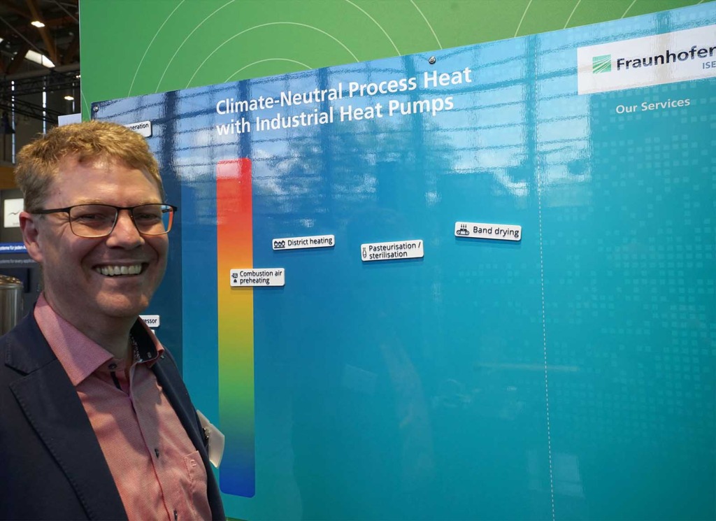 Karl-Anders Weiß vom Fraunhofer ISE vor einer Infotafel zu klimaneutraler Prozesswärme mit Industrie-Wärmepumpen auf der Chillventa 2026.